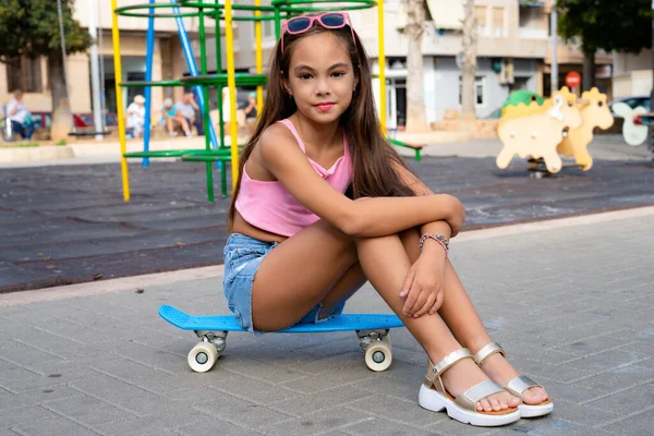 선글라스를 스케이트보드에 귀여운 야외에서 스케이트보드를 귀여운 소녀의 — 스톡 사진