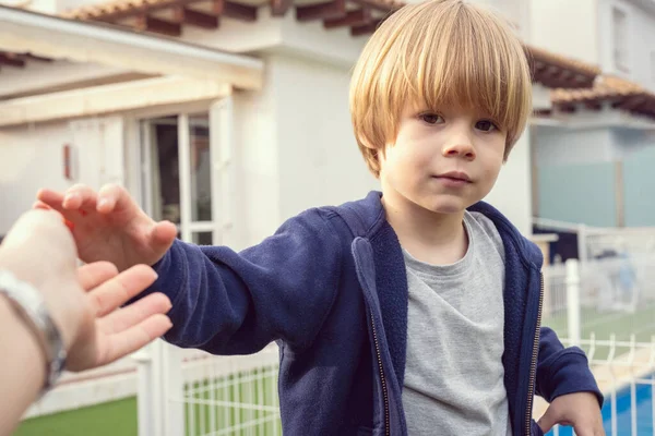 stock image Close up of cute child blond boy giving hug to mum outdoors.