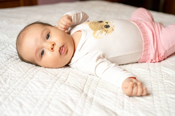 刚出生的女婴躺在柔软的毛毯上 睁开眼睛躺在床上 — 图库照片