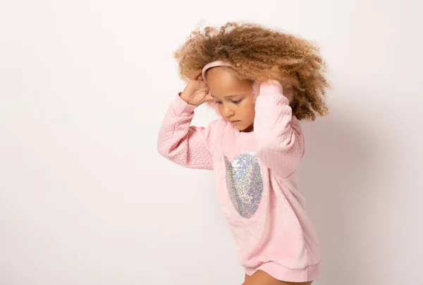 stock image Happy cute child girl with curly hair in pink dress standing isolated over white background.