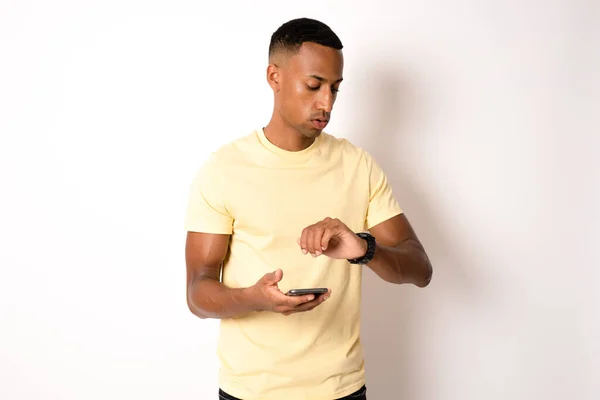 stock image Excited cheerful man wearing yellow t-shirt isolated over white background using mobile phone