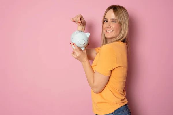 Mladá Blondýnka Žena Přes Růžové Pozadí Drží Prasátko Banky Šťastnou — Stock fotografie