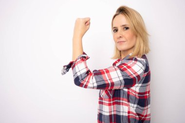 Soyutlanmış beyaz arka planı olan genç bir kadın güçlü bir jest yapıyor.