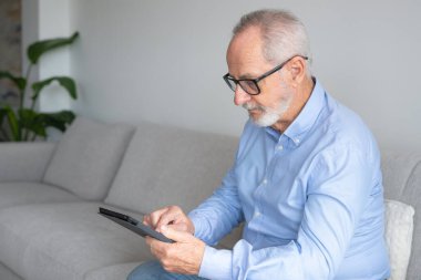 Komuta sizde dijital tablet haber okuma gülümseyerek. Evde, taşınabilir bilgisayarla neşeli heyecan olgun erkek kopya alanı