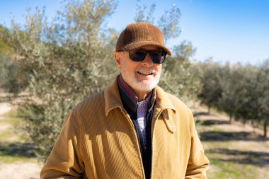 Elderly man smiling outdoors in nature looking away