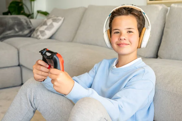 stock image Shot of an adorable young boy wearing headphones while playing video games at home.