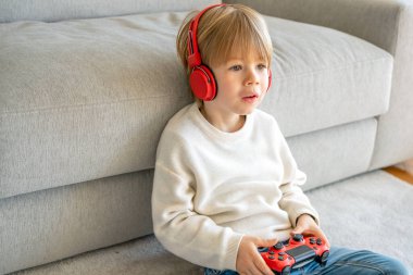 Evinde video oyunu oynayan küçük çocuk.