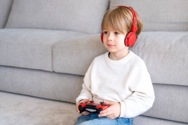 Evinde video oyunu oynayan küçük çocuk.
