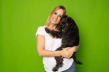 Parlak yeşil arka planda izole edilmiş, el ele tutuşan neşeli, dikkatli bir kızın portresi.