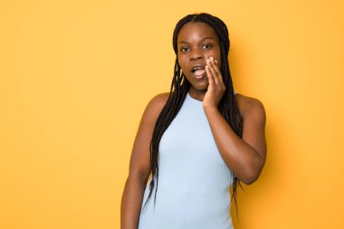 Sürpriz mutlu genç koyu tenli kadın şok ifade eder, baş ın yanında ellerini tutar.