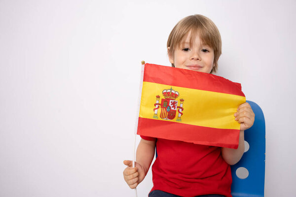 Young little caucasian kid with flag from Spain over isolated background with happy face.