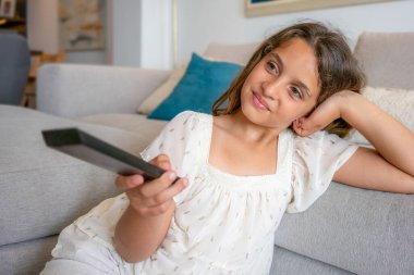 sevimli küçük kız kanepede televizyon izlerken