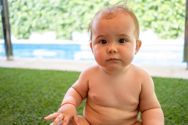閉じるアップの裸赤ちゃん女の子座って屋外で緑の草の背景 — ストック写真
