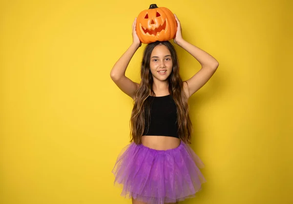 stock image Happy child girl celebrating Halloween standing isolated over yellow background.