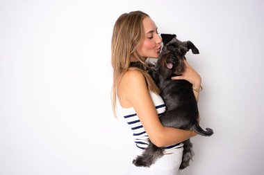 Mutlu bir yüzü olan pozitif bir kadın ve dışarı çıktıktan sonra köpeği tatmin oluyor, iyi ilişkileri var, beyaz arka planda izole edilmiş. Evcil hayvanlar ve insanlar.