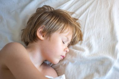 Kid sleeps face close up. Child boy take nap. Kid sleeping in bed. Comfortable mattress on bedroom. Soft pillow, comfy, cozy comfortable bed concept. Healthy kids sleeping.