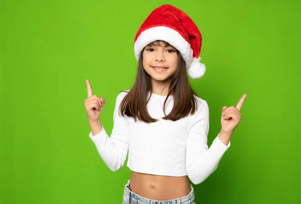 Маленькая Девочка Рождественской Шляпе Санты Показывающая Пальцами Зеленом Фоне Стоковое Фото