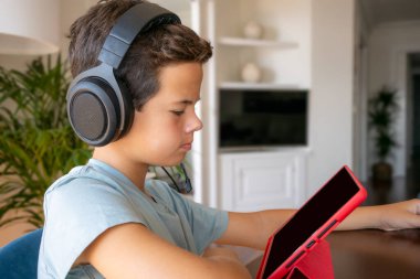 Akıllı telefon kullanan, rahat bir kanepede uzanan, hafta sonları dinlenen, boş vakitlerin tadını çıkaran, telefon ekranına bakan, mobil cihaz tutan, oyun oynayan, çizgi film izleyen tatlı bir çocuk.