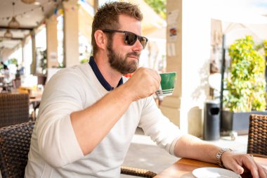 Bir kahve molası bir kafede oturan genç adam.