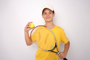 Beyaz arka plan üzerinde izole bir tenis raketi ile yakışıklı bir çocuk portresi