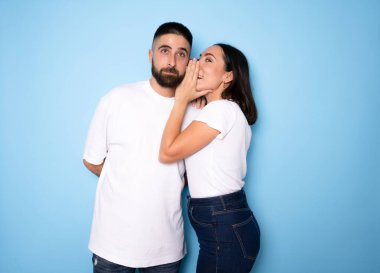 Esmer, mavi arka planda erkek arkadaşına gizli şeyler fısıldıyor.