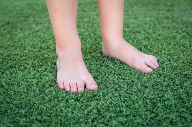 Yeşil çimlerin üzerinde çocuk ayakları