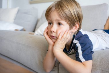 Tatlı sarışın bir çocuğun portresi, küçük bir çocuk, evde televizyon izliyor.