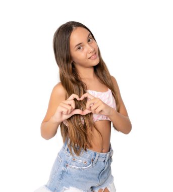 Güzel şirin kız kalp figürü yapıyor parmakları saydam arka planda soyutlanmış duruyor..