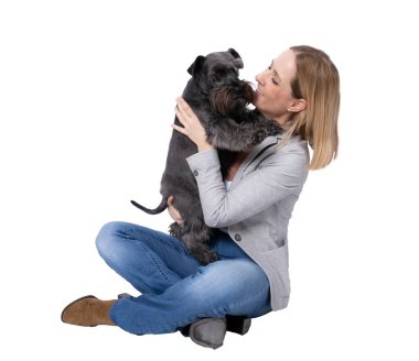 Genç mutlu kadın, şeffaf arka planda izole bir şekilde yerde oturan köpeğine sarılıyor. PNG şeffaf