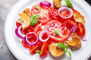 Domates salatası panzanella ekmeği, soğanlı sebzeli abur cubur masada fotokopi masası arka planında.