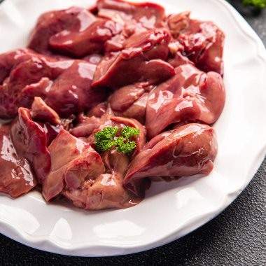 Ciğer tavuğu çiğ sakatat yemeği. Masanın üzerinde. Arka plandaki uzay yiyeceklerinin fotokopisi.