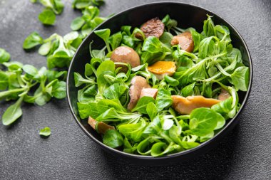 Salata mantarı, dilimler, abur cubur. Fotokopi masasında yemek. Arka planda yemek, köy manzarası. 