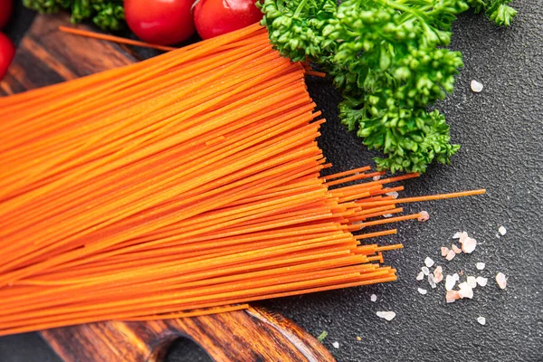 Kırmızı domates spagettisi çiğ makarna kırmızı hamurlu makarna taze sağlıklı yemek aperatifleri masa üzerinde fotokopi uzay yiyecekleri arka plan kırsal üst görünüm