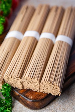 soba karabuğday eriştesi çiğ Asya atıştırmalığı. Masanın üzerinde yiyecek fotokopisi. Arka plan kırsal manzarası.