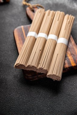 soba karabuğday eriştesi çiğ Asya atıştırmalığı. Masanın üzerinde yiyecek fotokopisi. Arka plan kırsal manzarası.