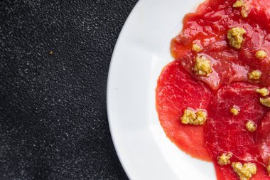 Carpaccio baharatlı et çiğ iştah açıcı zeytin, sığır eti ince dilimler masada taze sağlıklı yemek atıştırmalığı fotokopi uzayı arka plan kırsal manzarası