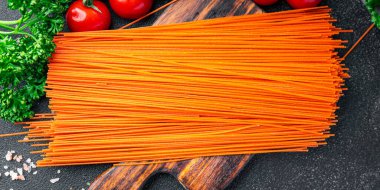 red spaghetti carrot juice dye raw pasta fresh healthy meal food snack on the table copy space food background rustic top view
