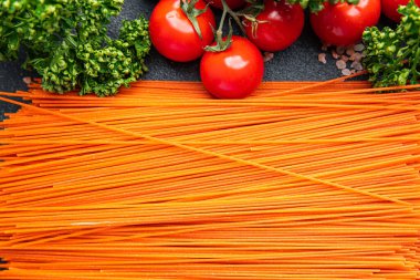 red spaghetti carrot juice dye raw pasta fresh healthy meal food snack on the table copy space food background rustic top view