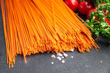 red spaghetti carrot juice dye raw pasta fresh healthy meal food snack on the table copy space food background rustic top view