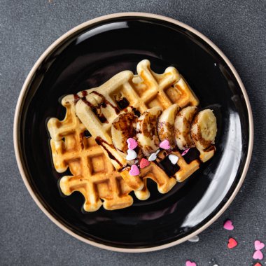 Belçika Waffle 'ı ya da Amerikan waffle' ı kahvaltısı ya da tatlı tatlı tatlı muz, masada çikolatalı yemek atıştırmalığı fotokopi uzayı arka plan kırsal manzarası
