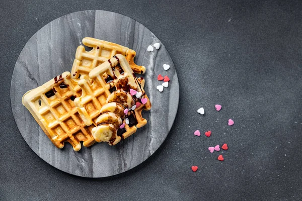 Belgian waffles or American waffles breakfast or sweet dessert banana, chocolate meal food snack on the table copy space food background rustic top view