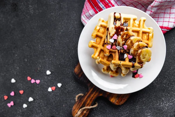 Belgian waffles or American waffles breakfast or sweet dessert banana, chocolate meal food snack on the table copy space food background rustic top view