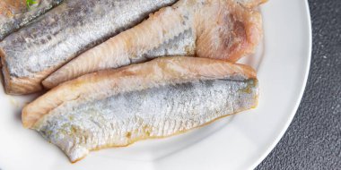 bonfile, kemiksiz balık, deniz ürünleri, abur cubur. Fotokopi masasında. Arka planda yiyecek, köy manzarası.