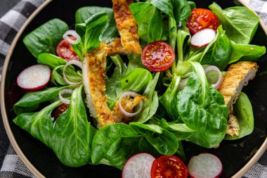 chicken salad meat, vegetable, tomato, radish, green leaves mix lettuce meal food snack on the table copy space food background rustic top view 