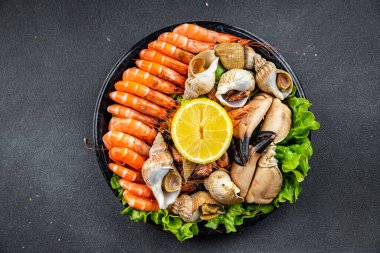 seafood plate assorted shrimps, crab claws, clams, rapan, trumpeter mollusk Takeaway healthy meal food snack on the table copy space food background rustic top view