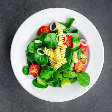 makarnalı yeşil salata Fusilli, domates, salatalık, yeşil yaprak karışımı salata, masada sağlıklı yemek atıştırmalığı fotokopi alanı arka plan kırsal manzarası