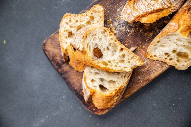 Taze baget ekmeği tam buğday unu, buğday ekmeği, ekşi ekmek sağlıklı yemek atıştırmalığı masa üzerinde fotokopi uzayı arka plan manzarası