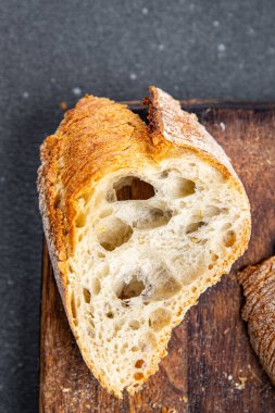 Taze baget ekmeği tam buğday unu, buğday ekmeği, ekşi ekmek sağlıklı yemek atıştırmalığı masa üzerinde fotokopi uzayı arka plan manzarası