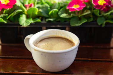 Dışarıdaki masada bir fincan kahve ve çiçeklerle çuha çiçeği çok renkli fotokopi odası arka plan kırsal manzarası