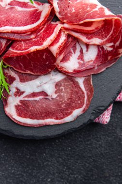 Coppa et sosisi, domuz budu, abur cubur. Fotokopi masasında. Arka planda yemek, köy manzarası.